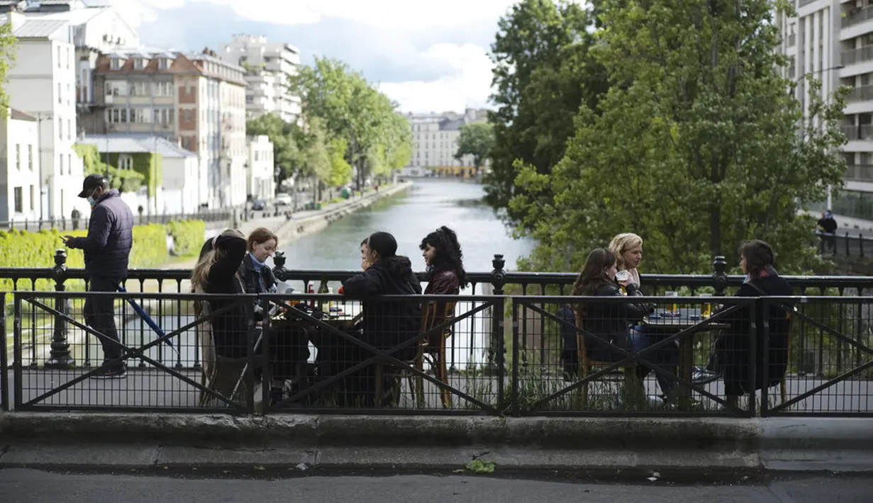 Pelanggan minum bir di teras kafe di Paris, Prancis, Rabu (19/5/2021). Prancis kembali membuka kafe dan restoran pada 19 Mei 2021 setelah ditutup lebih dari enam bulan karena pandemi virus corona COVID-19. (AP Photo/Lewis Joly)