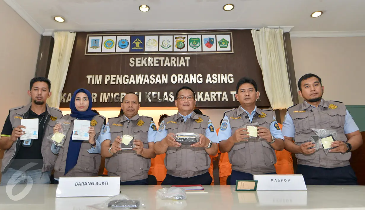 Petugas menunjukan pasport WNA saat rilis di kantor Imigrasi Kelas 1 Jakarta Timur, Rabu (18/1). Sebanyak 11 wna diamankan petugas imigrasi karena tidak memiliki surat resmi. (Liputan6.com/Yoppy Renato)
