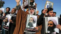 Pengunjuk rasa Syiah Irak meneriakkan slogan-slogan menentang pemerintah Saudi saat mereka memegang poster yang menunjukkan Syekh Nimr al-Nimr, yang dieksekusi di Arab Saudi. (AP)