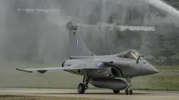 Sebuah jet Rafale disemprot dengan air saat angkatan udara Yunani memberi hormat kepada enam jet baru di pangkalan udara militer Tanagra, utara Athena, Yunani (19/1/2022). Rafale ini semakin memicu ketegangan dengan saingan bersejarah Yunani dan mitra NATO Turki. (AP Photo/Thanassis Stavrakis)