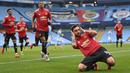 Gelandang Manchester United, Bruno Fernandes (depan) melakukan selebrasi usai mencetak gol pertama timnya ke gawang Manchester City melalui eksekusi penalti dalam laga lanjutan Liga Inggris 2020/21 di Etihad Stadium, Minggu (7/3/2021). MU menang 2-0 atas Mancity. (AFP/Laurence Griffiths/Pool)