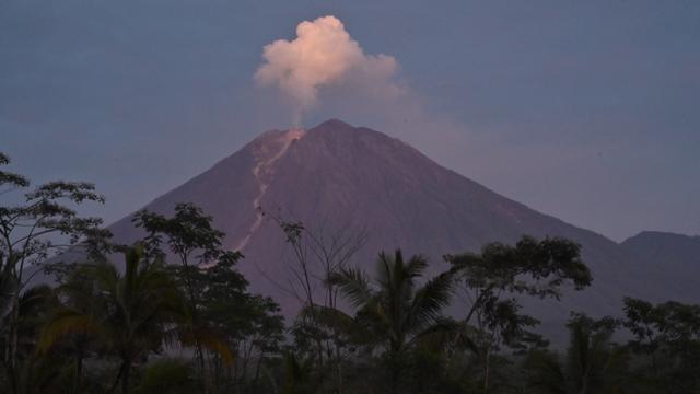 Gunung Semeru mengeluarkan lahar panas yang terlihat dari desa Curah Kobokan di Lumajang, Jawa Timur, Rabu (8/12/2021).  Rabu pagi cuaca sekitar gunung Semeru terlihat cerah. Badan gunung juga tidak terhalang kabut dan bisa terpantau dengan jelas. (ADEK BERRY / AFP)