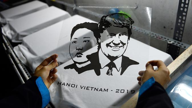 Seorang pekerja Vietnam bersiap untuk mencetak kaus bergambar wajah Presiden AS Donald Trump dan pemimpin Korea Utara Kim Jong-un di Hanoi, Jumat (22/2). Pembuatan kaus itu menyambut KTT kedua AS-Korea Utara pada 27 Februari mendatang. (Nhac NGUYEN/AFP)