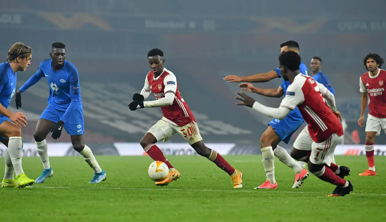 Striker Arsenal, Eddie Nketiah (tengah) berlari ke gawang saat bek Norwegia Molde Martin Bjornbak (kiri) dan bek Molde Gambia Sheriff Sinyan (kedua dari kiri) mendekat pada pertandingan grup B Liga Europa di Emirates Stadium di London (5/11/2020). Arsenal menang telak atas Molde 4-1. (AFP/Glyn Kirk)