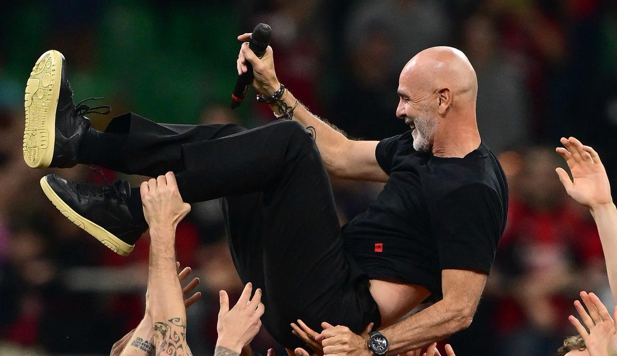 Pioli, arsitek kemenangan liga dua tahun lalu, mendapat tepuk tangan meriah dari para penggemar dan para pemainnya, yang kemudian mengangkatnya beramai-ramai. (MARCO BERTORELLO / AFP)