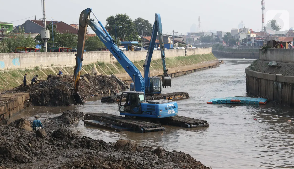 Petugas menggunakan alat berat melakukan proses pengerukan endapan tanah di aliran Sungai Ciliwung, Jakarta, Selasa (28/7/2020). Pengerukan endapan ini untuk memperlancar aliran air Sungai Ciliwung serta upaya pencegahan banjir saat musim hujan. (Liputan6.com/Helmi Fithriansyah)