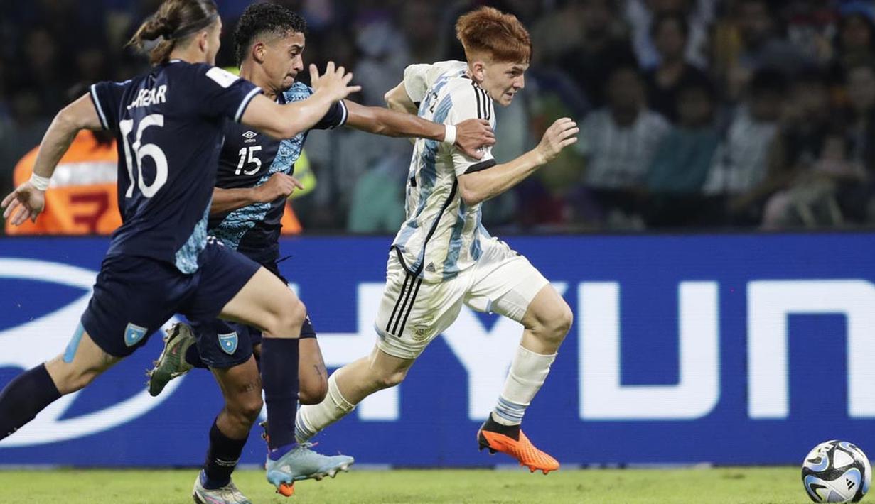 Pemian Timnas Argentina U-20, Valentin Barco, berusaha melewati pemain Guatemala, Andy Dominguez, pada laga Grup A Piala Dunia U-20 2023 di Estadio Unico Madre de Ciudades, Rabu (24/5/2023). Argentina membungkam Guatemala tiga gol tanpa balas. (AP Photo/Nicolas Aguilera)