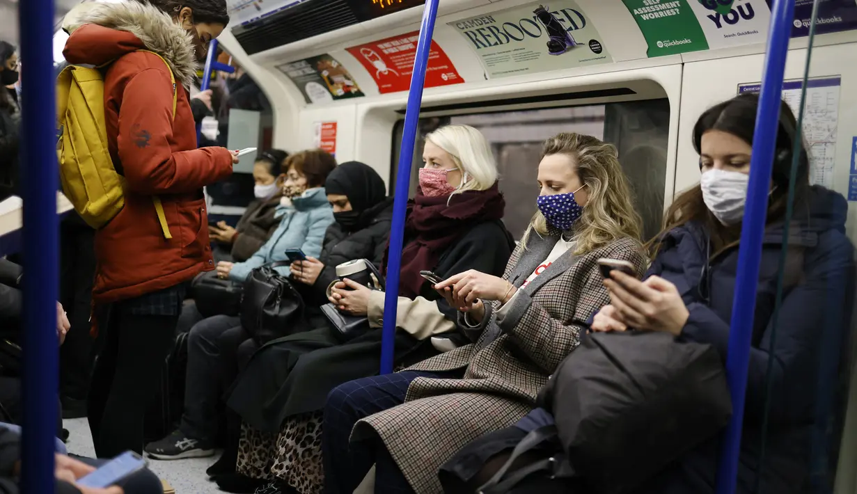 Penumpang melakukan perjalanan dengan kereta bawah tanah Transport for London (TfL) Victoria Line menuju pusat kota London (5/1/2022). Rumah sakit Inggris telah kekurangan staf yang disebabkan oleh gelombang infeksi Omicron, kata pemerintah pada hari Selasa (4/1). (AFP/Tolga Akmen)