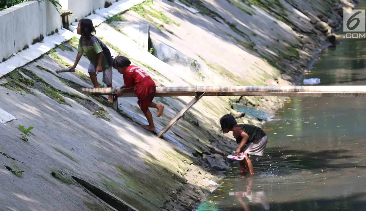 Anak-anak bermain di sungai di Jakarta, Sabtu (7/4). Gubernur DKI Jakarta Anies Baswedan memastikan akan tetap membangun Ruang Terbuka Hijau (RTH). RTH yang dimaksud yakni membangun Taman Maju Bersama dan Taman Pintar. (Liputan6.com/Angga Yuniar)