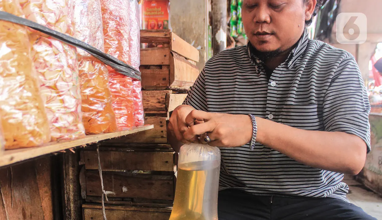 Pedagang memasukkan minyak goreng curah ke dalam kantong plastik di Pasar Kebayoran, Jakarta, Selasa (31/5/2022). Kementerian Perindustrian mencabut subsidi minyak goreng curah kepada pelaku usaha mulai Selasa (31/5/2022). (Liputan6.com/Johan Tallo)