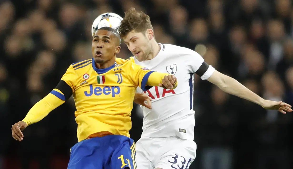 Gelandang Juventus, Douglas Costa, duel udara dengan bek Tottenham Hotspur, Ben Davies, pada laga Liga Champions di Stadion Wembley, London, Rabu (7/3/2018). Tottenham Hotspur takluk 1-2 dari Juventus. (AP/Frank Augstein)