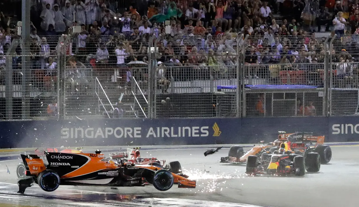 Mobil pembalap McLaren Fernando Alonso, melayang setelah bertabrakan dengan pembalap Ferrari, Kimi Raikkonen pada awal Grand Prix Singapura Formula One di Sirkuit Marina Bay City, Singapura, Minggu, (17/09). (AP Photo / Wong Maye-E)