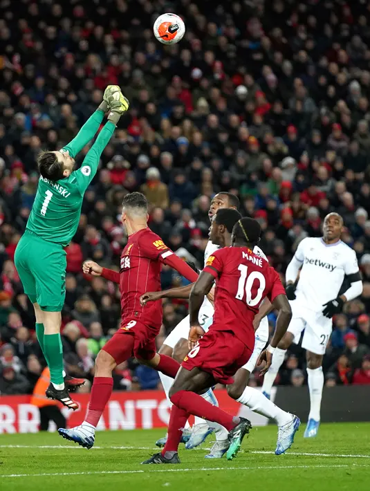 Kiper West Ham Lukasz Fabianski meninju bola saat menghadapi Liverpool pada pertandingan Liga Inggris di Stadion Anfield, Liverpool, Inggris, Senin (24/2/2020). Liverpool mengalahkan West Ham dengan skor 3-2. (AP Photo/Jon Super)