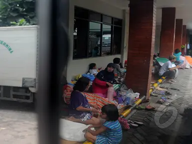 Guyuran hujan deras membuat warga Rw 01 Kampung Pulo Jatinegara warga mengungsi di pelataran RS Hermina, Jakarta, Selasa (10/2/2015). (Liputan6.com/Herman Zakharia)