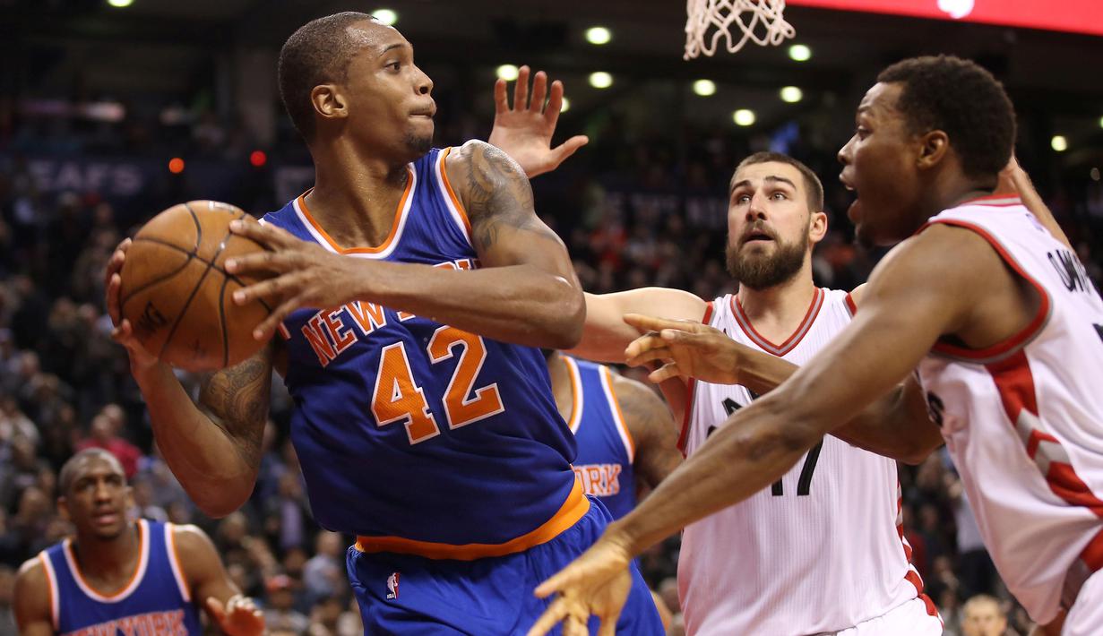 Pebasket New York Knicks Lance Thomas (42) mencoba melepaskan tembakan saat dibayangi para pebasket Toronto Raptors di Air Canada Centre, Toronto, Canada, Rabu(11/11/2015) WIB. Knicks menang Raptors 111-109. (Reuters/Tom Szczerbowski-USA TODAY Sports)