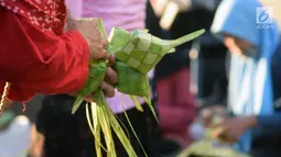 Pedagang dan pembeli bertransaksi kulit cangkang ketupat di Pasar Peterongan Semarang, Jawa Tengah, Kamis (12/6). Warga membeli kulit ketupat yang dijual Rp 12.000 per ikat itu untuk melengkapi aneka masakan khas Lebaran. (Liputan6.com/Gholib)