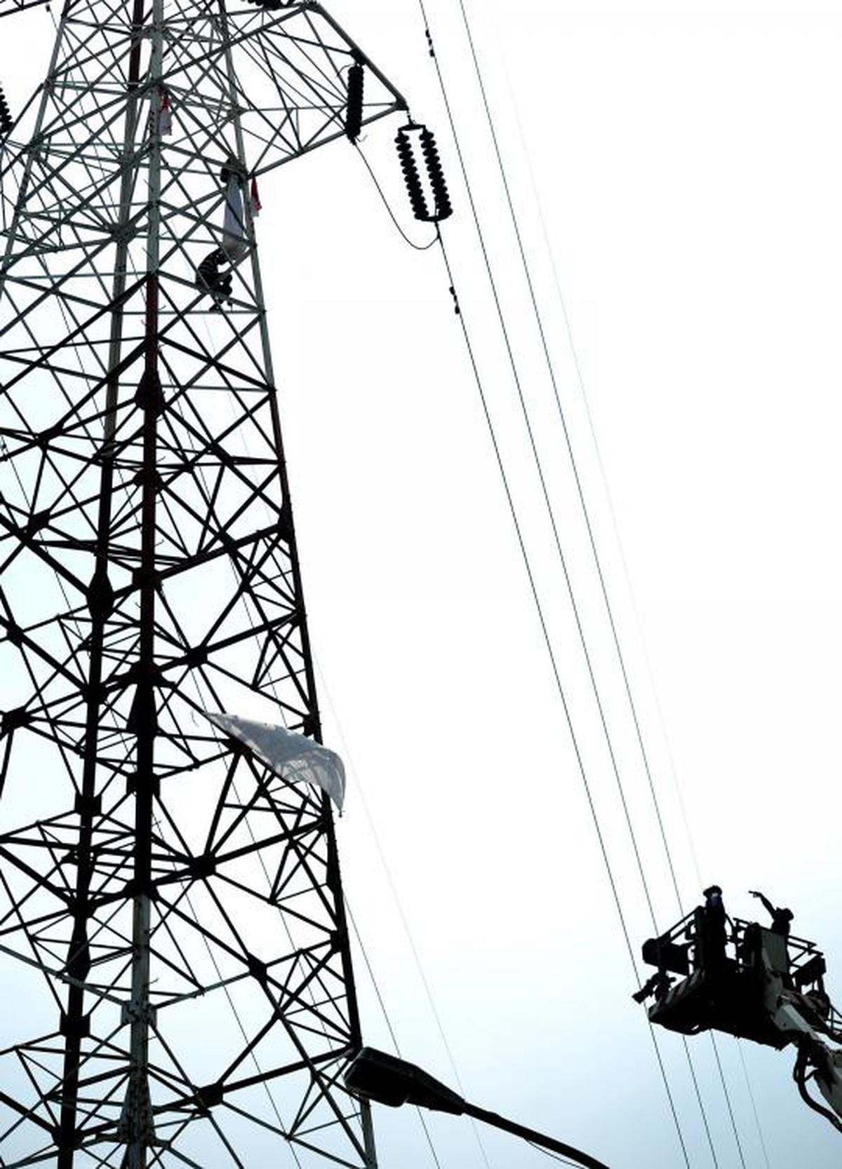 Pria berpakaian pocong di atas tower SUTET