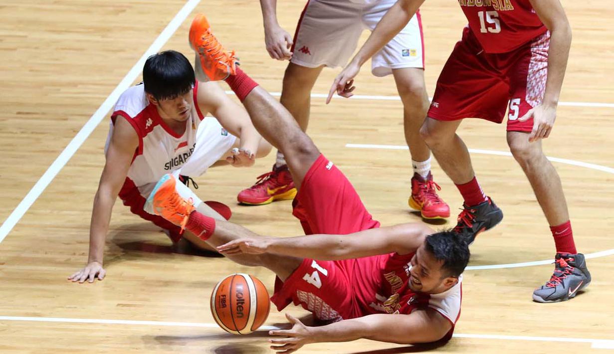 Pebasket putra Indonesia, Adhi Pratama Prasetyo Putra (14), berusaha melewati hadangan pemain Singapura dalam semi final basket SEA Games 2015. (Bola.com/Arief Bagus)