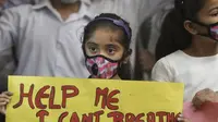 Seorang anak perempuan India memegang poster memprotes polusi udara di India, New Delhi, India, 6 November 2016 (AP)