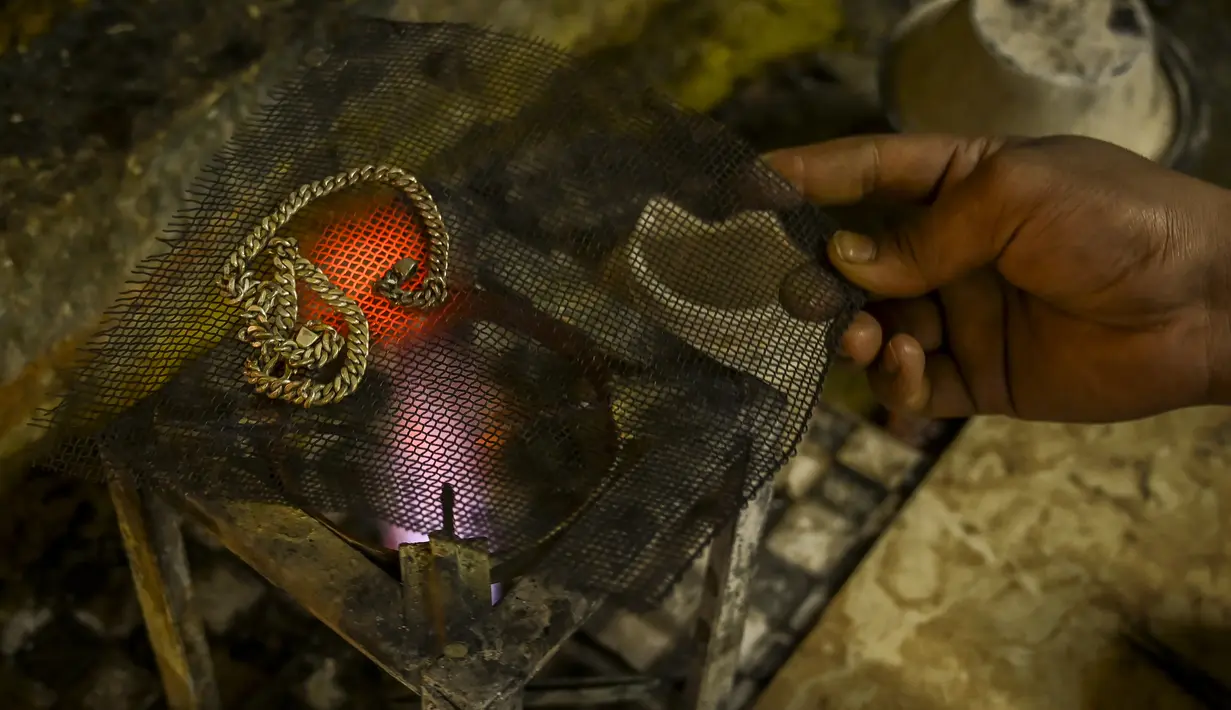 Perajin membuat ornamen di bengkel perhiasan emas di Srinagar (24/6/2021). Srinagar merupakan menjadi salah satu pusat industri kerajinan perhiasan emas. (AFP/Tauseef Mustafa)