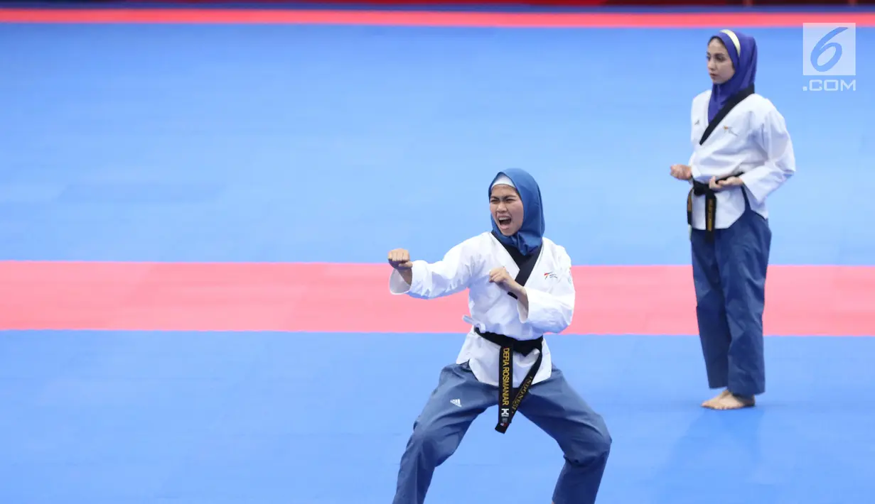 Atlet Taekwondo putri Indonesia, Defia Rosmaniar (kiri) saat beraksi melawan Salahshouri Marjan (Iran) pada Final Women Individual Poomsae di JCC, Jakarta, Minggu (19/8). Defia Rosmaniar berhasil meraih emas. (Liputan6.com/Helmi Fithriansyah)