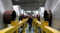 Pekerja memeriksa gulungan aluminium di sebuah pabrik di Zouping di provinsi Shandong bagian timur China (23/11/2019). Zouping adalah salah satu negara terkaya di negeri ini. Kemakmuran ekonominya bergantung pada pengembangan industri aluminium. (AFP Photo/STR)