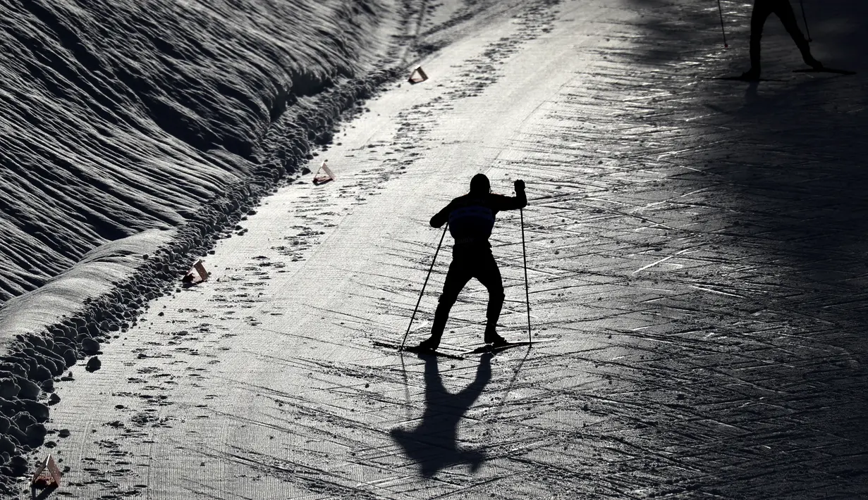 Seorang atlet melakukan pemanasan di lintasan bersalju dalam kejuaraan Nordic Combined World Cup di Austria. (Foto: AP/Matthias Schrader)