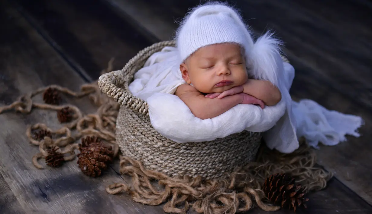 Seorang bayi yang baru lahir berpose saat menjalani sesi foto di Banda Aceh pada 18 November 2019. Merekam momen bayi baru lahir lewat fotografi belakangan sedang menjadi tren para orangtua baru di Indonesia. (Photo by CHAIDEER MAHYUDDIN / AFP)