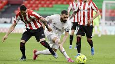 Striker Real Madrid, Karim Benzema, berusaha melewati pemain Athletic Bilbao, Alex Berenguer, pada laga Liga Spanyol di Stadion San Mames, Minggu (16/5/2021). Real Madrid menang dengan skor 1-0. (AP Photo/Alvaro Barrientos)