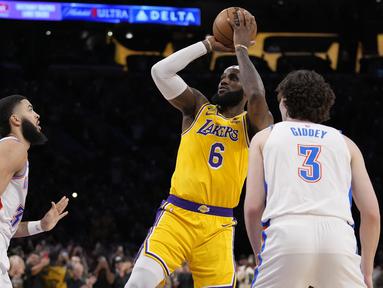 Bintang LA Lakers, LeBron James sukses pecahkan rekor Kareem Abdul Jabbar sebagai pemain NBA dengan perolehan poin terbanyak sepanjang masa. Rekor fenomenal tersebut dicatatkannya saat LA Lakers menghadapi Oklahoma City Thunder di Crypto.com Arena, Los Angeles, Rabu (8/2/2023) pagi WIB. Dalam laga tersebut LeBron James total mengemas 38 poin, sehingga total mengoleksi 38.390 poin sepanjang kariernya di NBA, melewati torehan Kareem Abdul Jabbar yang total mengumpulkan 38.387 poin. (AP Photo/Ashley Landis)