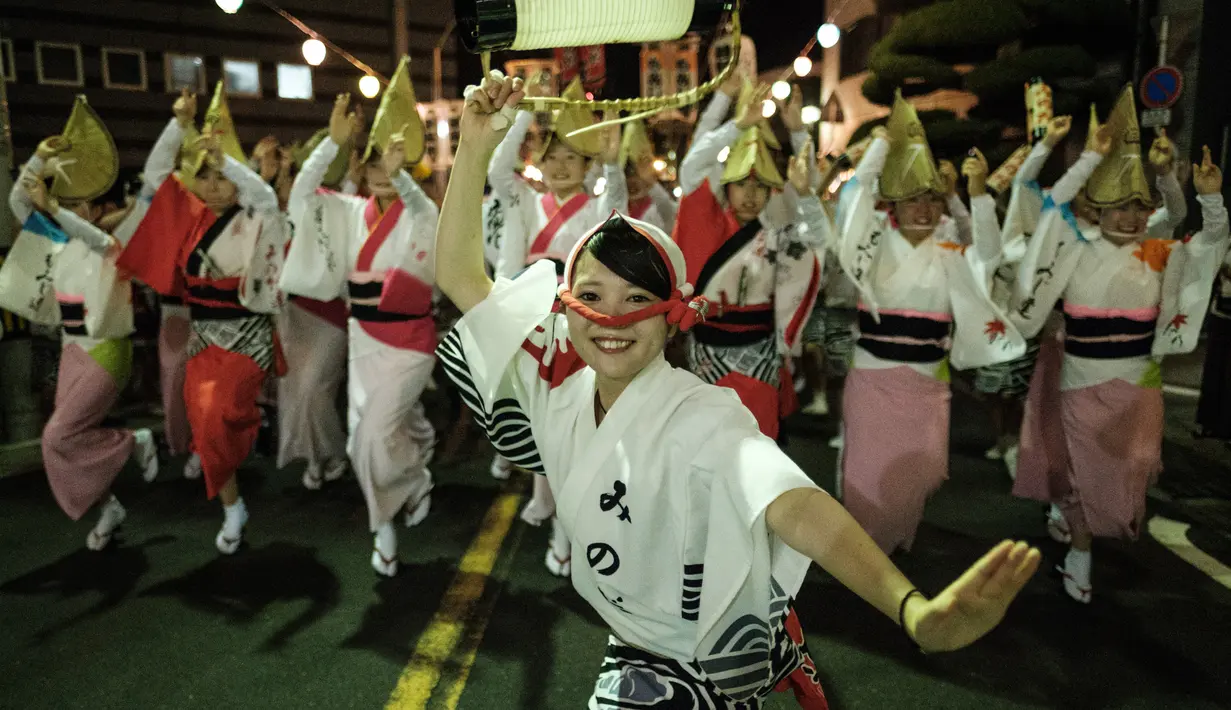 Sejumlah penari tampil di jalan Ikeda saat festival Awa Odori di Kota Miyoshi, Jepang (16/8). Awa Odori yang memiliki sejarah 400 tahun ini selalu menarik ribuan pengunjung dan penari ke Tokushima pada pertengahan Agustus. (AFP Photo/Yasuyoshi Chiba)