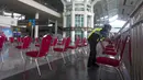 Seorang pekerja membersihkan kursi ruang tunggu Bandara Internasional Ngurah Rai di Bali, Sabtu (9/10/2021). Bandara Internasional Ngurah Rai akan kembali dibuka setelah ditutup lebih dari setahun karena pandemi COVID-19. (AP Photo/Firdia Lisnawati)