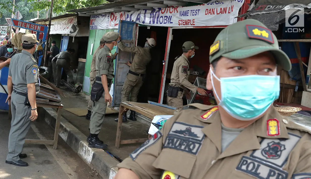 Petugas Satpol PP membongkar bangunan semi permanen di Jalan Nusantara Raya, Depok, Jawa Barat, Rabu (18/4). Pembongkaran dilakukan untuk menertibakan bangunan liar yang berdiri di sepanjang trotoar. (Liputan6.com/Immanuel Antonius)