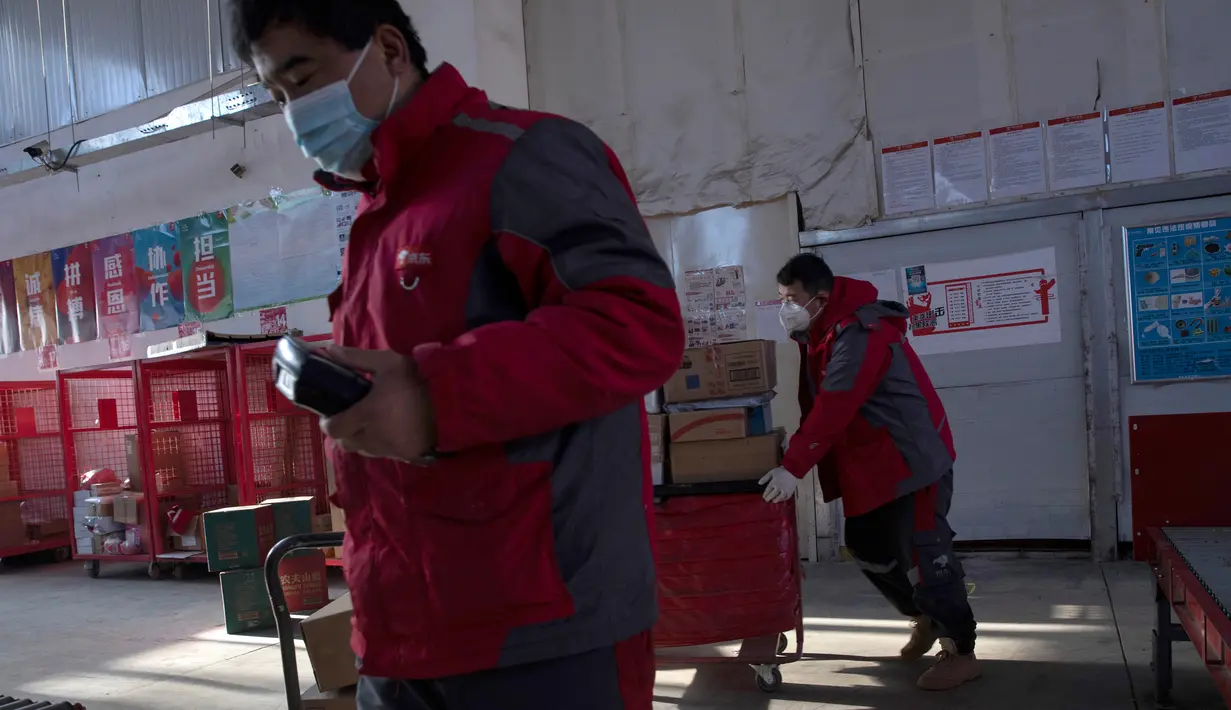 Kurir sibuk memilah paket di pusat distribusi di Beijing, China, Selasa (18/2/2020). E-commerce adalah salah satu dari sedikit industri yang berkembang setelah penutupan pabrik, restoran, bioskop, kantor, dan toko terkait wabah virus corona atau COVID-19. (AP Photo/Ng Han Guan)