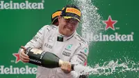 Pembalap Mercedes Nico Rosberg dari Jerman merayakan kemenangannya dengan membuka botol sampanye di podium setelah balapan F1 Grand Prix Italia, di Monza, Italia Minggu (04/9). Balapan ini merupakan kemenangan ketujuh di musim ini. (Reuters/Max Rossi)