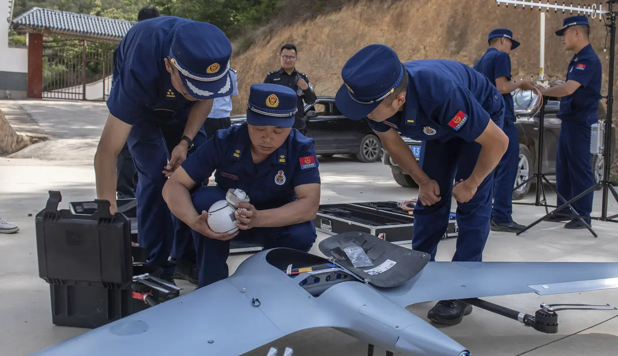 Para petugas menyiapkan drone untuk memantau kawanan gajah liar Asia di kabupaten E'shan di Provinsi Yunnan, China barat daya (28/5/2021). Kerugian yang dialami lebih dari $ 1 juta sejak kawanan gajah tersebut berkeliaran keluar dari kawasan cagar alam pada pertengahan April. (Hu Chao/Xinhua via AP)