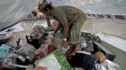 Seorang warga merapikan barang-barangnya di atas kapal pasca penggusuran permukiman Pasar Ikan, Jakarta, Selasa (13/4). Warga Pasar Ikan mengaku belum mendapat rumah susun sewa yang telah dijanjikan oleh Pemprov DKI Jakarta. (Liputan6.com/Faizal Fanani)