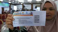 Warga menunjukan tiket mudik bareng  2016 dengan Jasa Raharja di Jakarta, Kamis (16/6). Mudik bareng 2016 nantinya akan mengantarkan pemudik menggunakan bus dengan tujuan pulau Jawa dan Sumatera. (Liputan6.Com/Angga Yuniar)