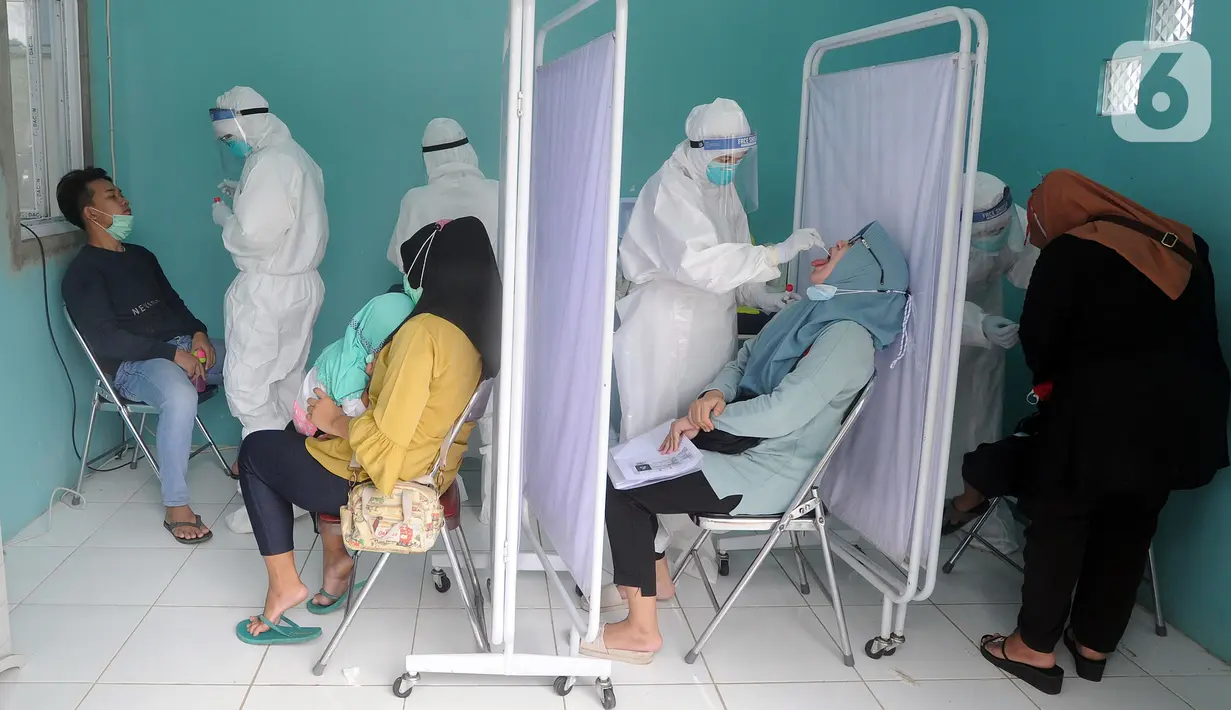 Paramedis melakukan swab test PCR kepada warga di Puskesmas Kramat Jati, Jakarta Timur, Rabu (13/1/2020). Setiap harinya, Puskesmas Kramat Jati menyediakan kuota 300 swab test PCR  secara gratis untuk memutus mata rantai penyebaran COVID-19. (merdeka.com/Arie Basuki)