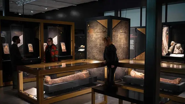 anggota staf memeriksa artefak dalam pameran Golden Mummies of Egypt di Museum Manchester, barat laut Inggris, 23 Februari 2023.