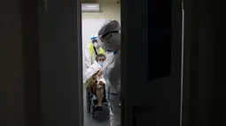 Petugas medis mempersiapkan pasien dengan virus corona untuk pemeriksaan CT scan di aula perawatan rumah sakit sementara COVID-19 di Istana Es Krylatskoye di Moskow, Rabu (10/2/2021). Rusia mencatat lebih dari empat juta kasus infeksi virus Corona atau COVID-19. (AP/Alexander Zemlianichenko)