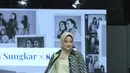 Titi Kamal memadukan outer panjang two tone yang unik. Satu sisi outer tersebut berwarna hijau lime yang senada dengan inner-nya. Sisi lainnya yang didominasi warna navy-hijau emerald selaras dengan celana panjang yang ia kenakan. [Dok/Fimela/Adrian Utama P].