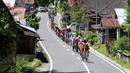 Pebalap melintasi perkampungan sepanjang etape ke-5 Tour de Singkarak dari Pantai Carocok-Painan menuju pantai Gondoriah-Pariaman, Sumatera Barart. (Bola.com/Nicklas Hanoatubun)