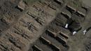 Pria dengan alat pelindung diri menggali kuburan baru di pemakaman Chacarita, Buenos Aires, Argentina, 12 Agustus 2020. Pemakaman Chacarita merupakan tempat banyak korban COVID-19 dimakamkan (AP Photo/Gustavo Garello)