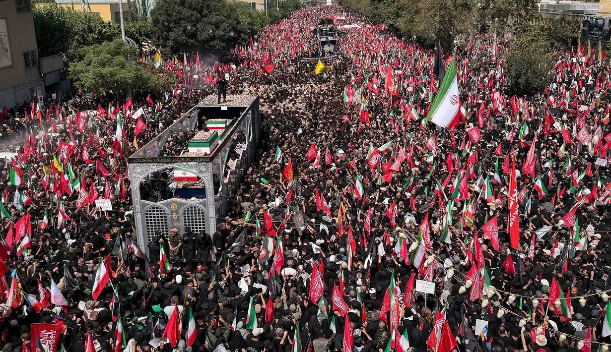 Sebuah truk yang membawa peti jenazah Pemimpin Tertinggi Iran Ayatollah Ali Khamenei dan anggota keluarganya melintas di tengah kerumunan pelayat selama prosesi pemakaman di Teheran, Iran, Senin, 6 Juli 2026. (AP Photo/Vahid Salemi)