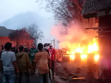 Sejumlah warga dan petugas penyelamat saat mengevakuasi warga lainnya yang dekat dengan zona merah Gunung Sinabung, Kabupaten Karo, Sumatera Utara, (22/5). Sedikitnya 6 orang tewas dalam bencana ini. (Tuty/Basarnas)