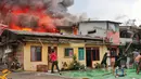 Warga berusaha memadamkan api saat terjadi kebakaran di kawasan padat penduduk di Jalan Simprug Golf II RT 4/8, Grogol Selatan, Kebayoran Lama, Jakarta Selatan, Minggu (21/8/2022). Belum diketahui penyebab kebakaran yang membakar puluhan rumah tersebut. (Liputan6.com/Angga Yuniar)