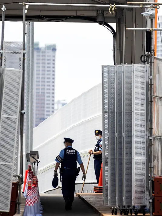 Seorang petugas polisi berjaga di pintu masuk kawasan wisma atlet Olimpiade dan Paralimpiade Tokyo 2020, di Tokyo pada Rabu (14/7/2021). Pembukaan pesta olahraga terbesar di dunia itu tinggal menghitung hari di tengah pandemi COVID-19. (Behrouz MEHRI / AFP)