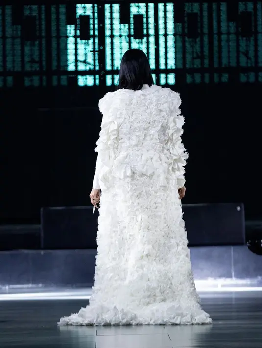 Ia mengenakan rancangan Harry Halim, yaitu blazer dress putih, dengan cape panjang menjuntai hingga ke lantai. [Foto: Instagram/harryhalim]