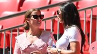 Annie Kilner, tunangan pemain Inggris Kyle Walker (kanan) berbincang Coleen Rooney, istri mantan pemain Inggris Wayne Rooney pada grup D Euro 2020 antara Inggris melawan Kroasia di stadion Wembley, London (13/6/2021). Annie tampil mengenakan jersey Inggris dan kacamata hitam. (AFP/Pool/Glyn Kirk)